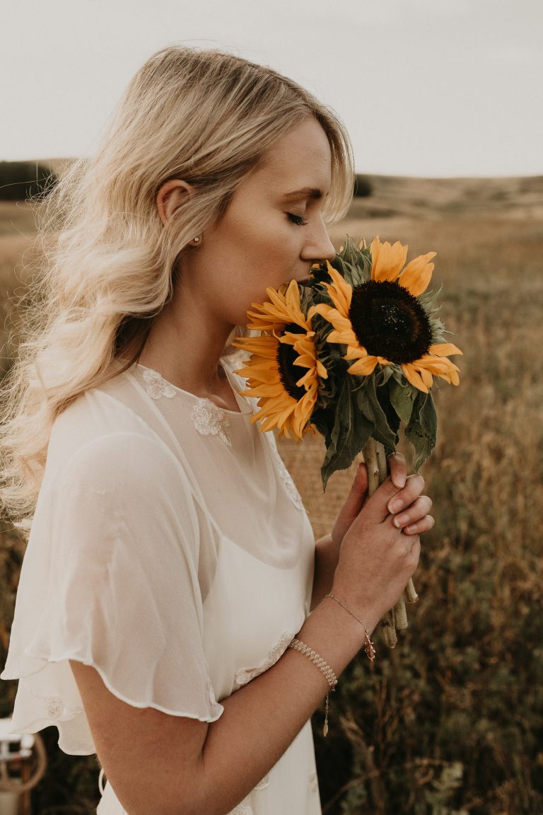 bride holding sunflowers at nose hill park calgary